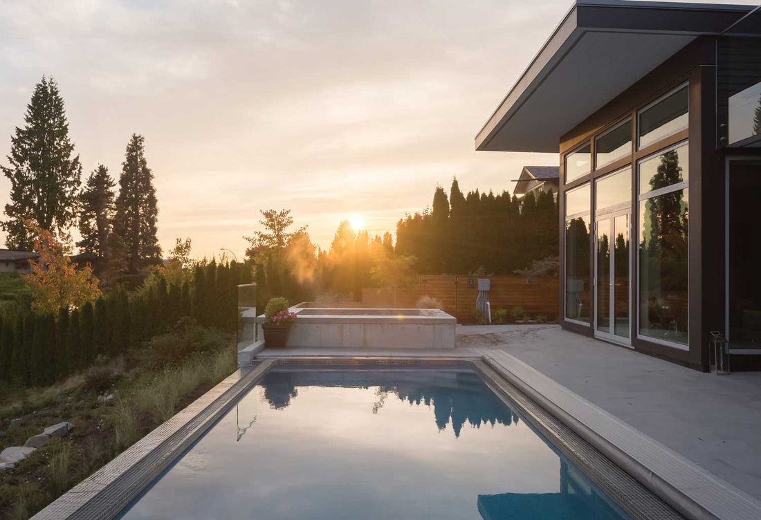 A rectangular Latham fiberglass pool with a tanning ledge and stone surround