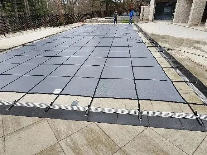 A long, precise fit. Webbing and perimeter anchors follow the full length of the pool.