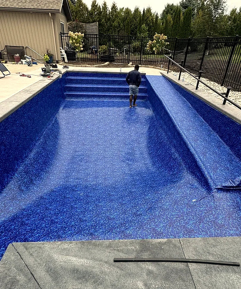 A pool built in concrete with a full-length bench ledge, finished with a patterned liner
