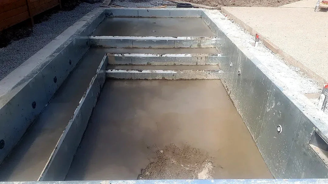Fresh concrete poured for new pool steps and a bench ledge