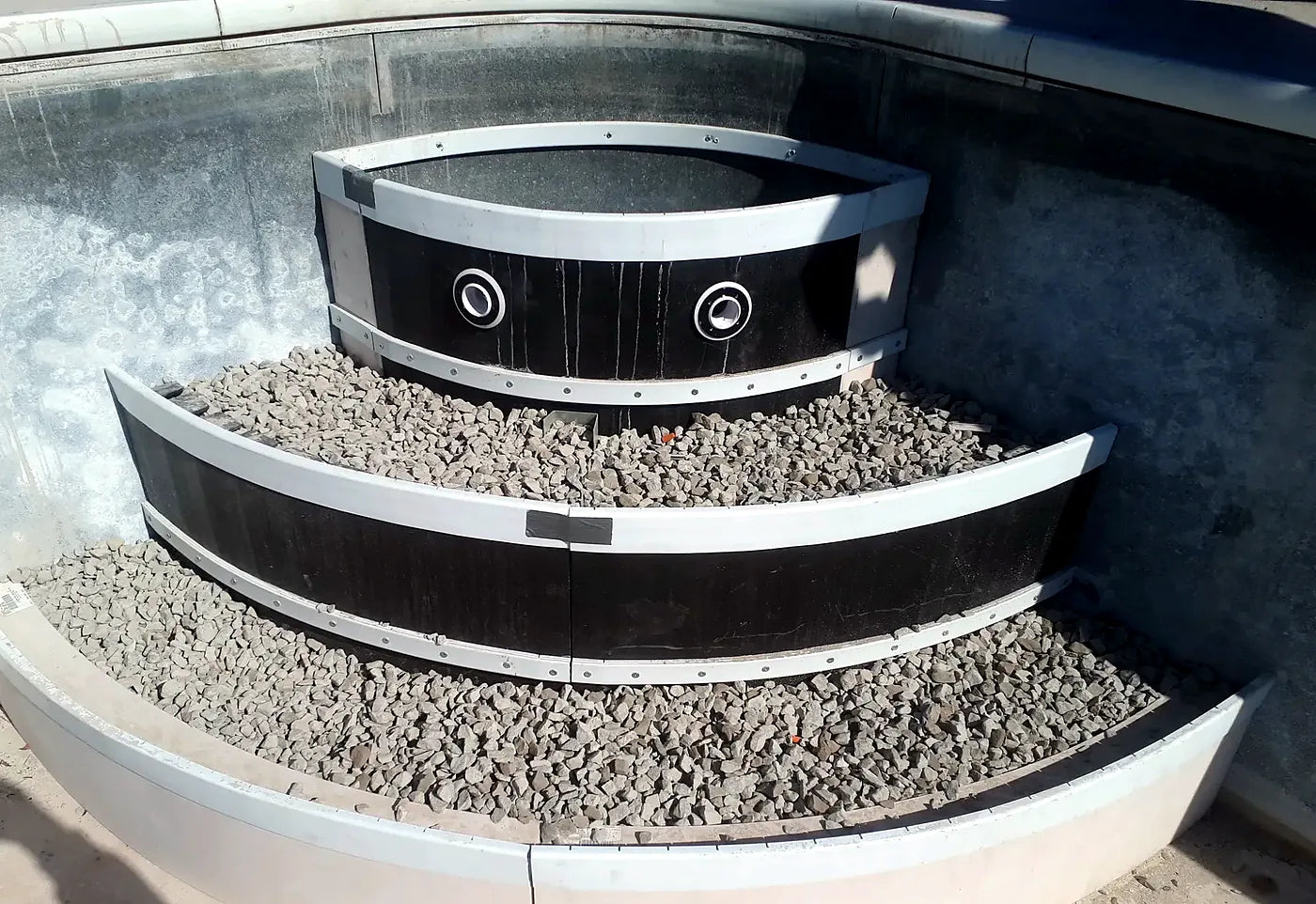 Curved forms set for new pool steps, filled with gravel ahead of the concrete