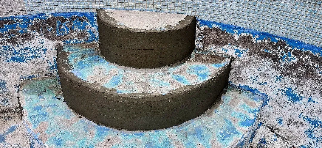 Curved pool steps rebuilt in grey repair mortar