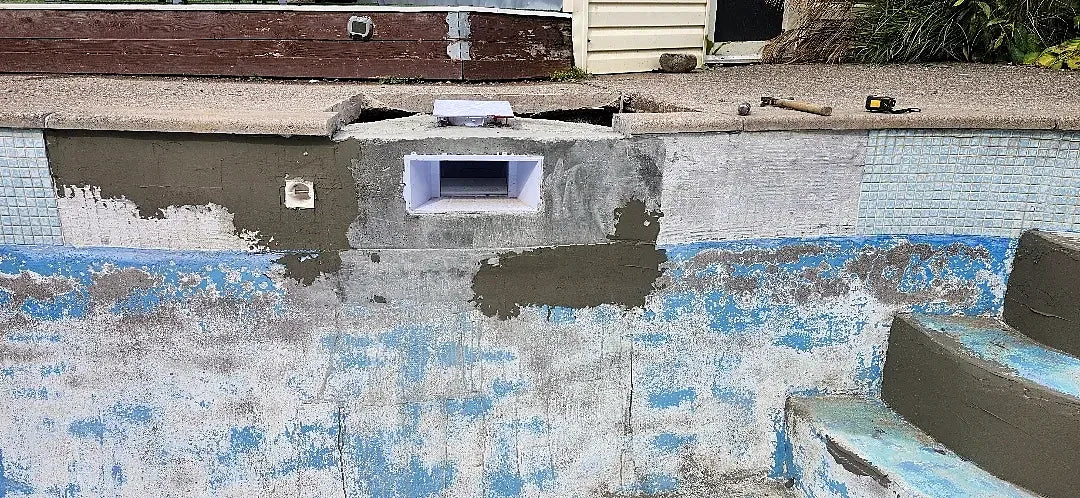 New skimmer set into the wall with fresh concrete patching around it
