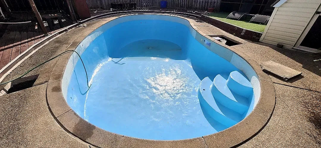 The finished light blue epoxy pool with its curved steps