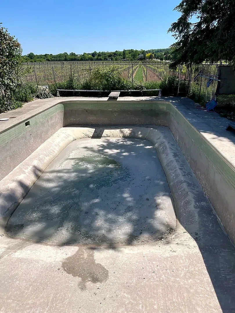 Before: a drained rectangular pool with a worn grey interior and green mosaic waterline